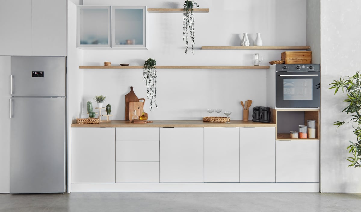 Cocina moderna reformada con mobiliario blanco y encimera de madera